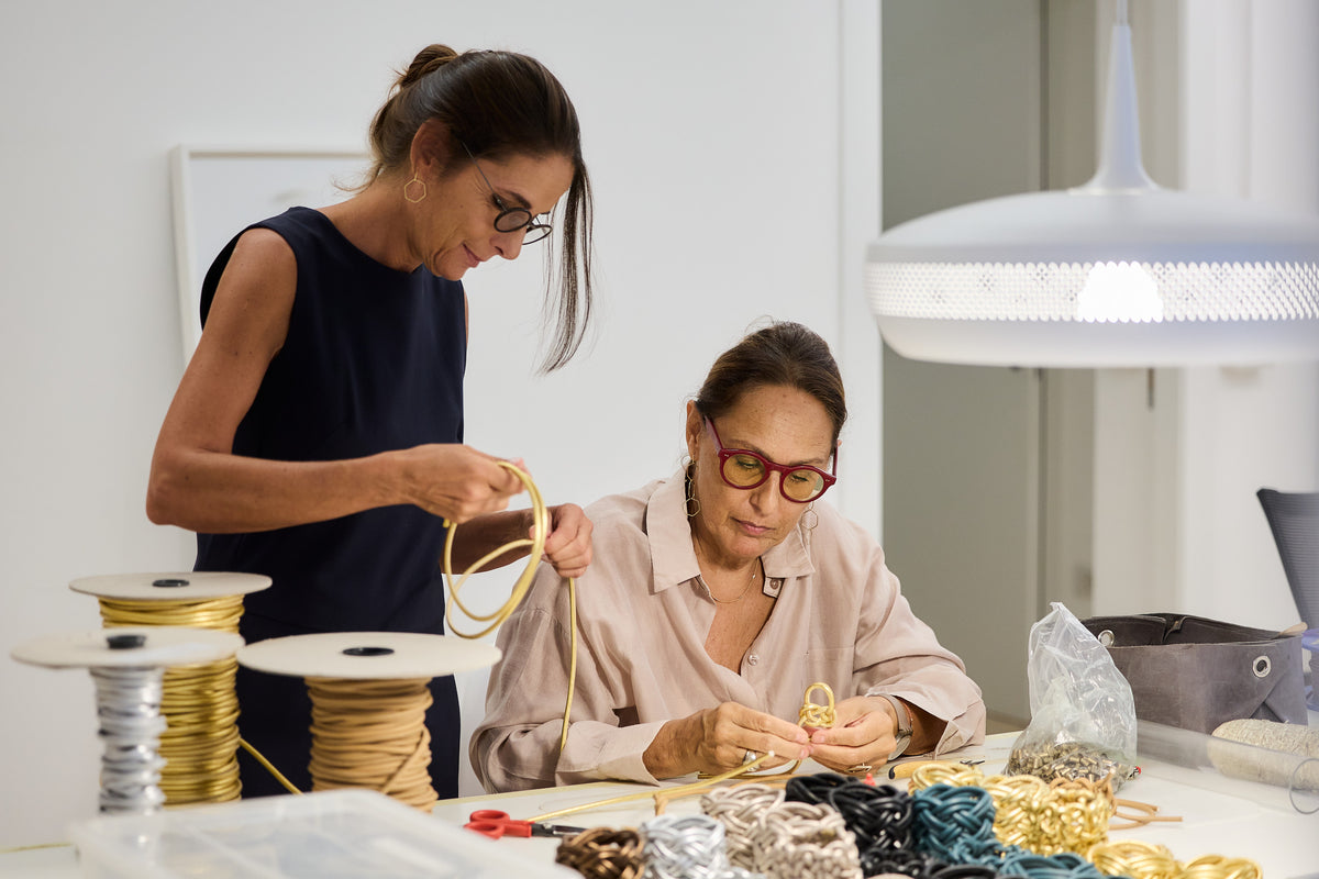 Due donne al banco del laboratorio Ellesanti lavorano fili e bobine
