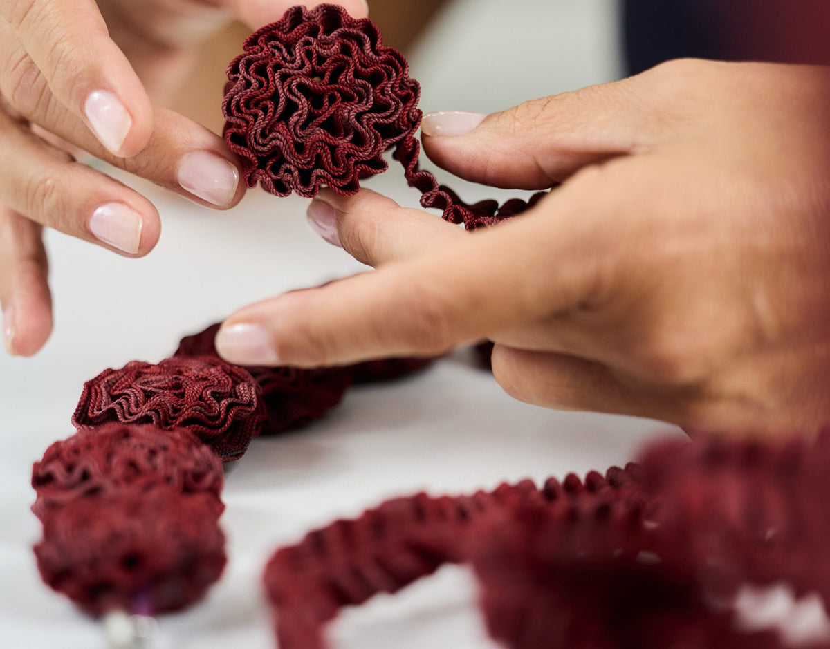 Hands working a burgundy cord