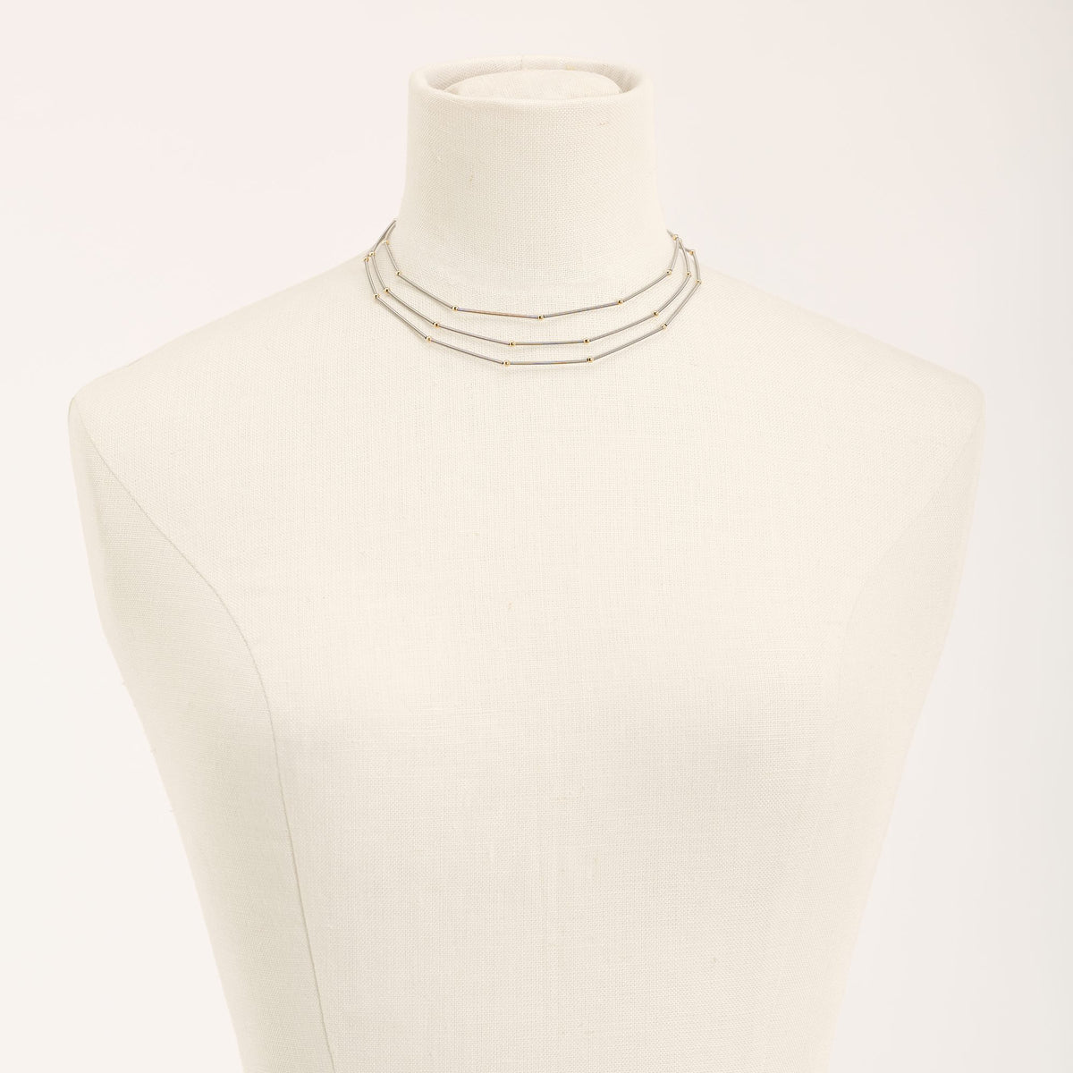 Collana Astro Tris Oro in acciaio e argento dorato, su fondo chiaro