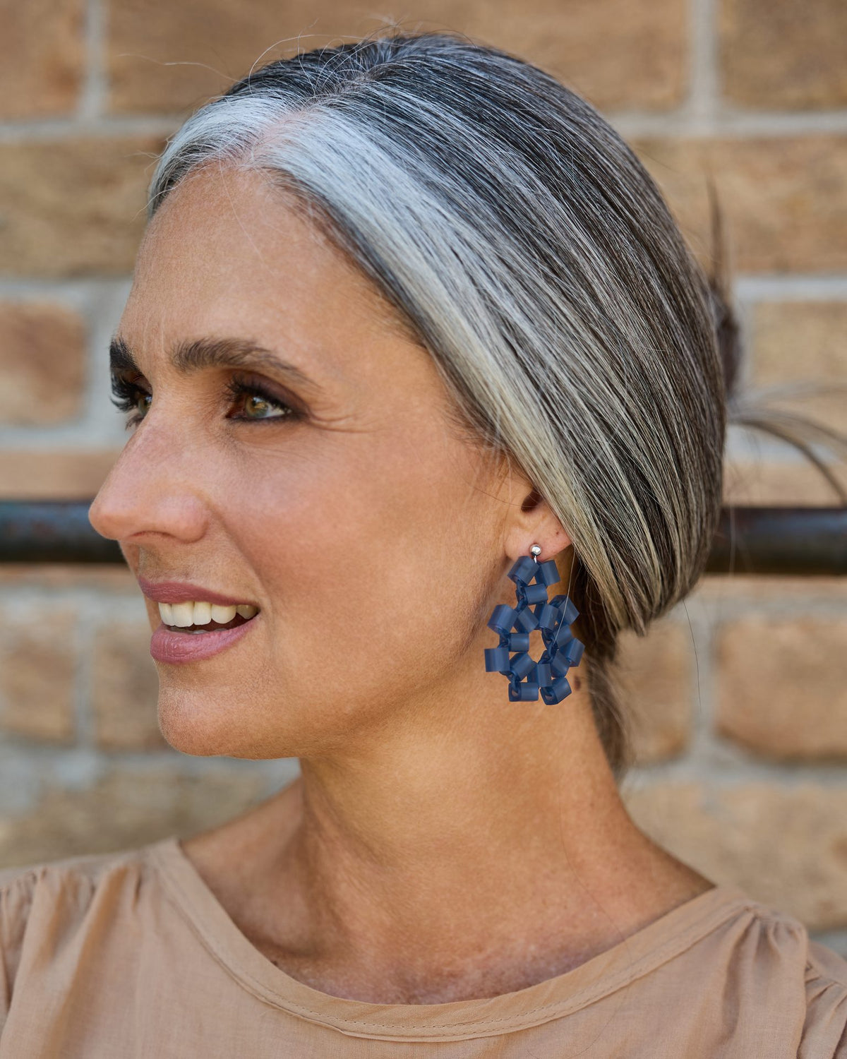 Orecchini Block blu indossati da una donna dai capelli grigi