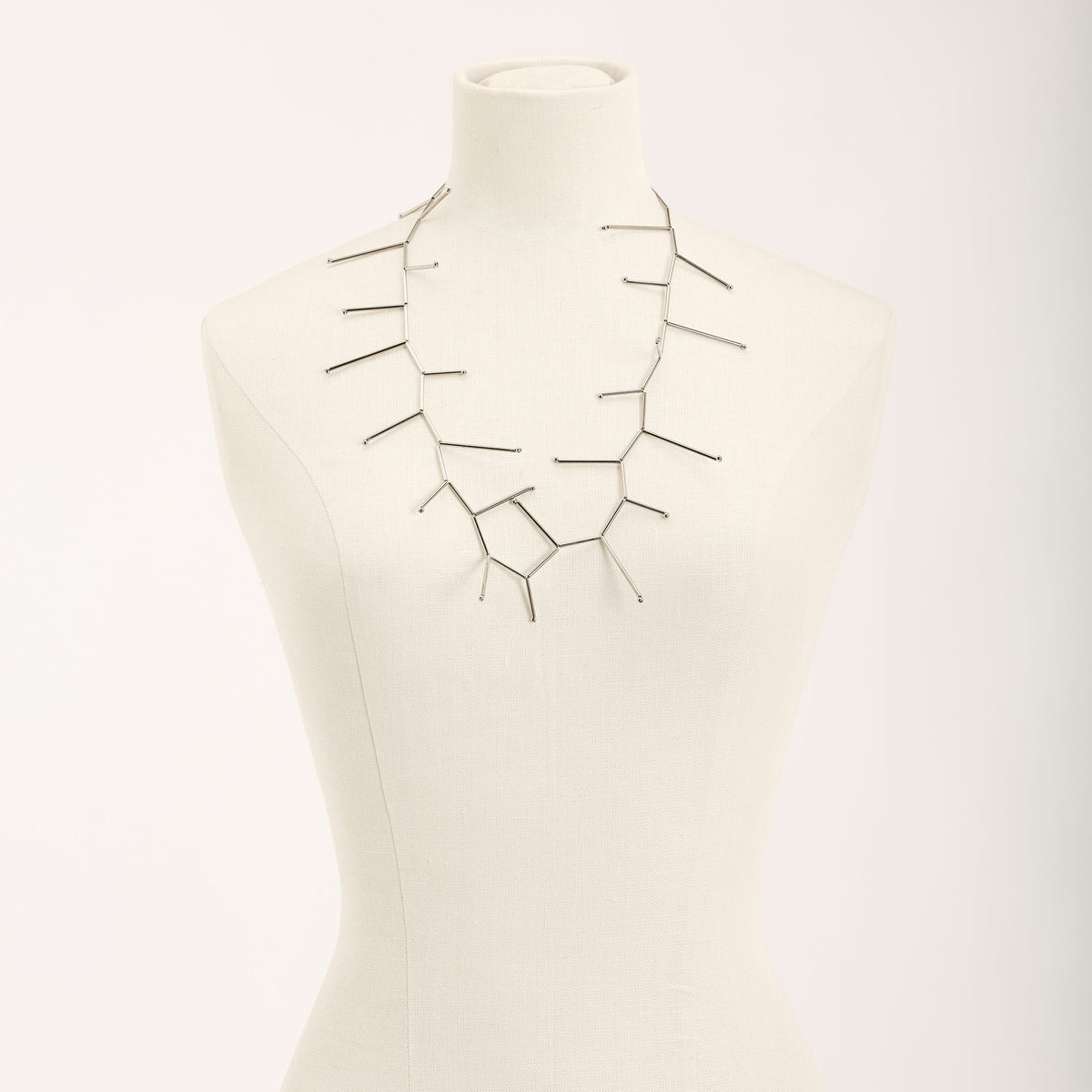 Collana Fenice Rodio in tubini in ottone rodiato e argento, su fondo chiaro
