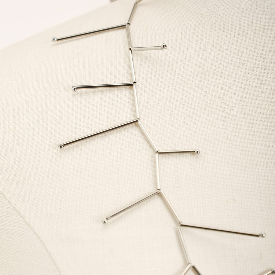 Fenice Rhodium necklace in rhodium-plated brass tubes and silver, close-up detail on a light background