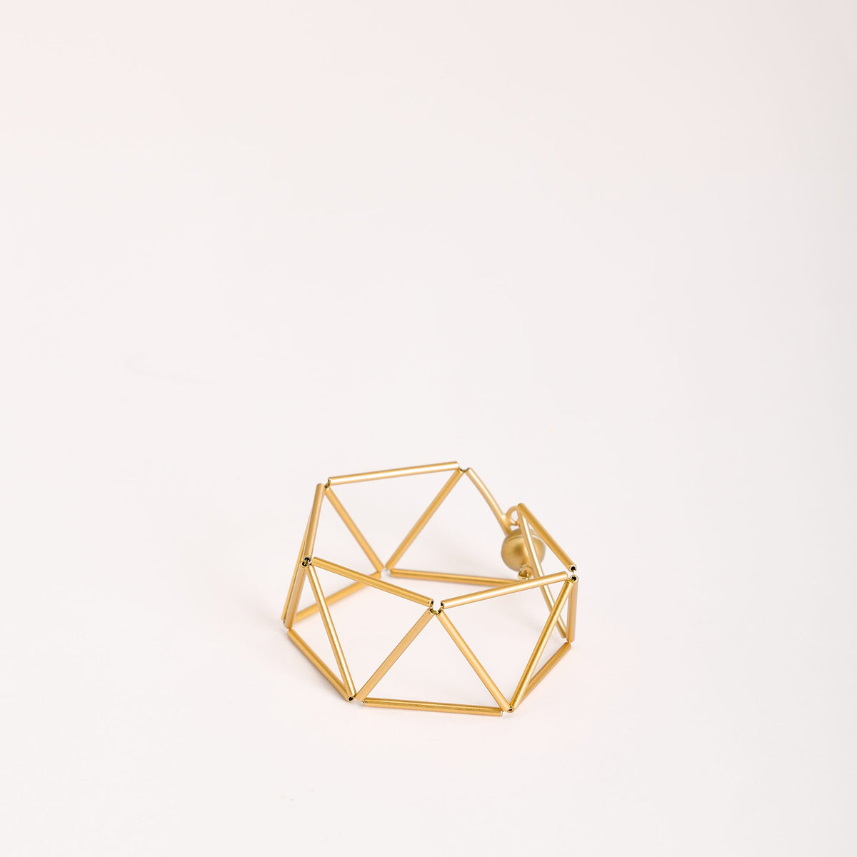 Greca Gold bracelet in gold-plated brass, on a light background