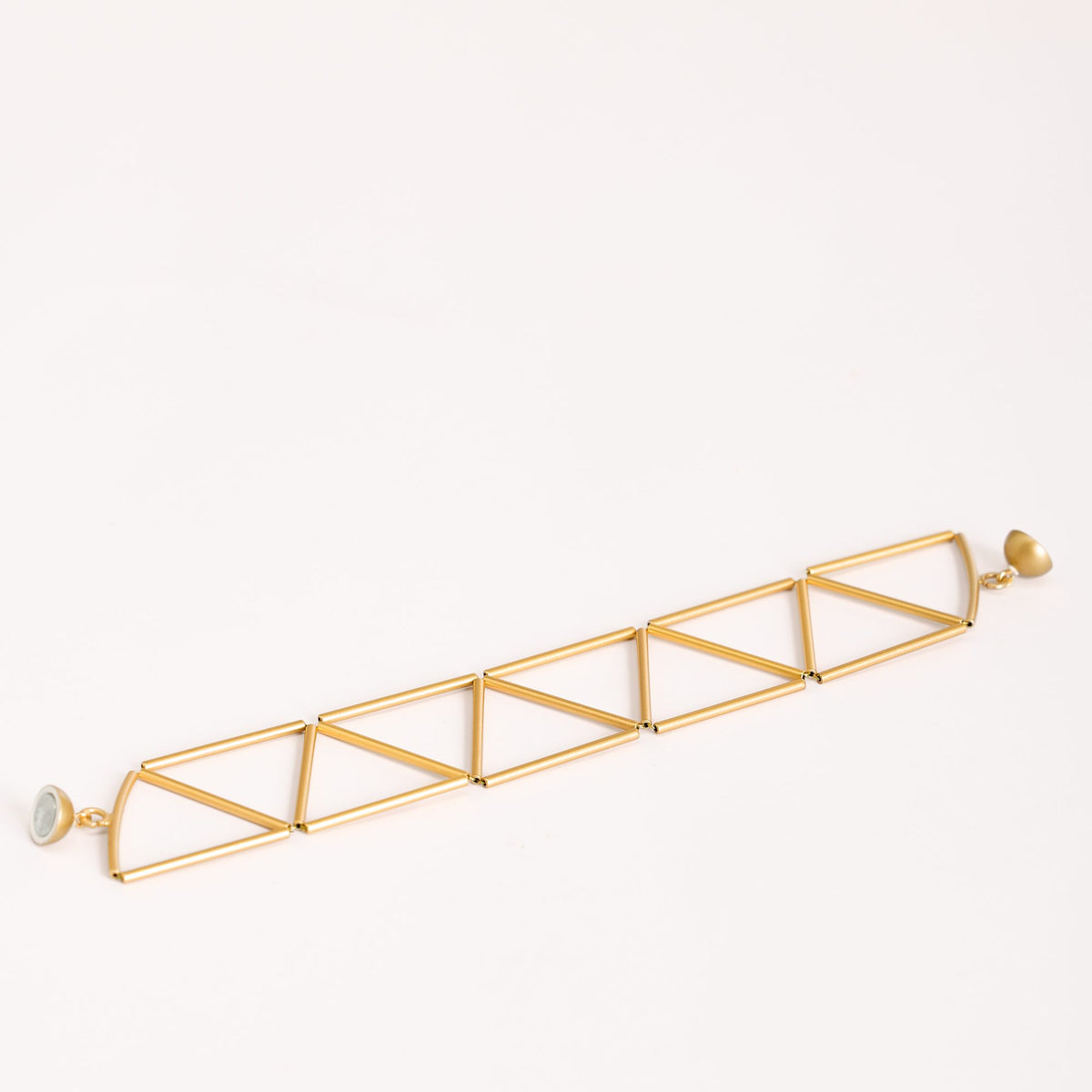 Bracciale Greca Oro in ottone dorato, dettaglio ravvicinato su fondo bianco