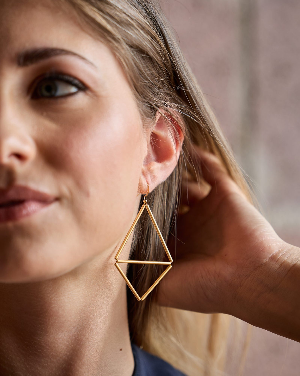 Kite 2 Gold earrings in gold-plated brass and gold-plated silver, worn, close-up on the ear