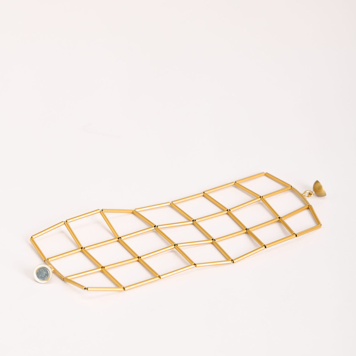 Bracciale Losanghe 3 Oro in ottone dorato e chiusura magnetica in resina, dettaglio ravvicinato su fondo bianco