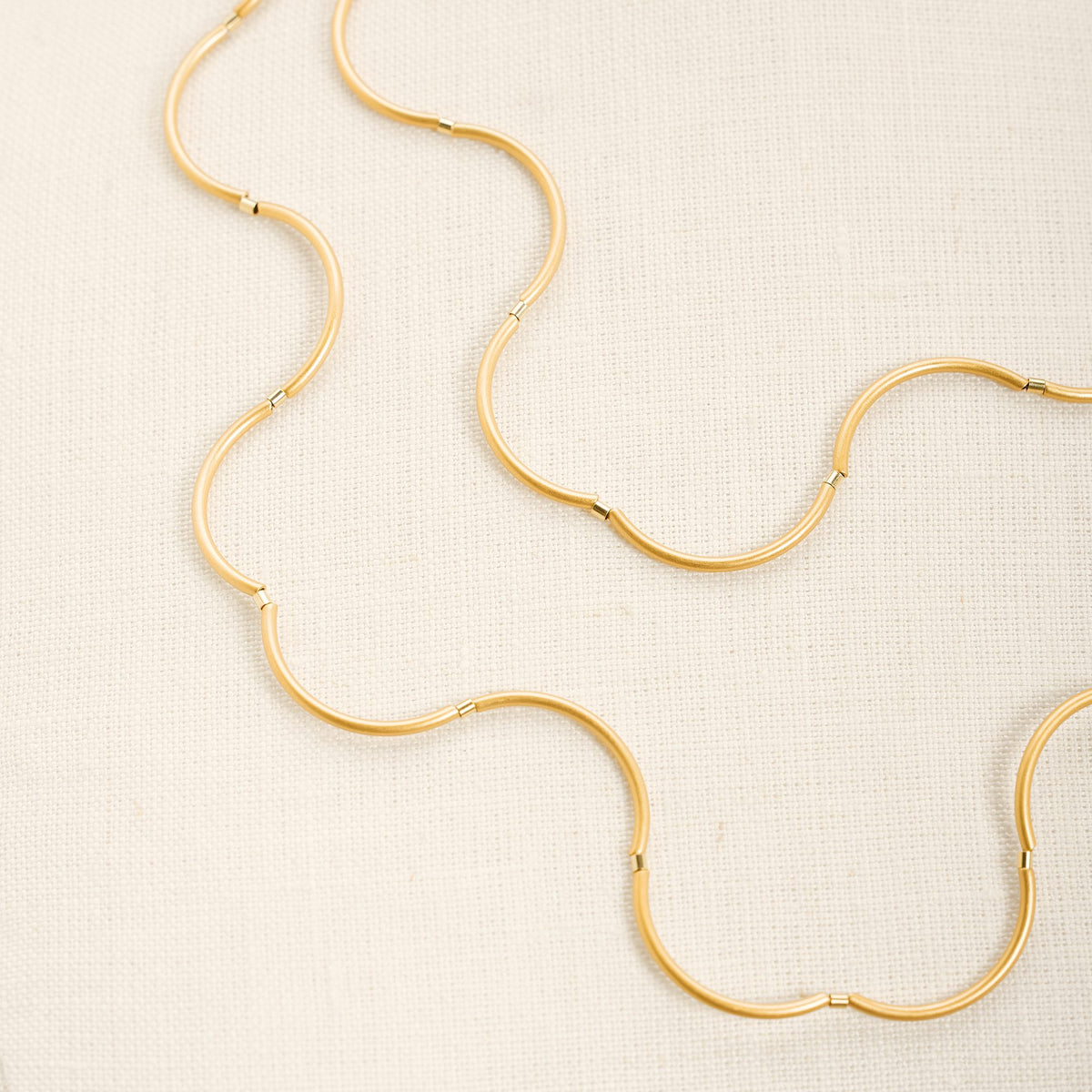 Collana Onda Oro in ottone dorato e tubini in argento dorato, su fondo chiaro