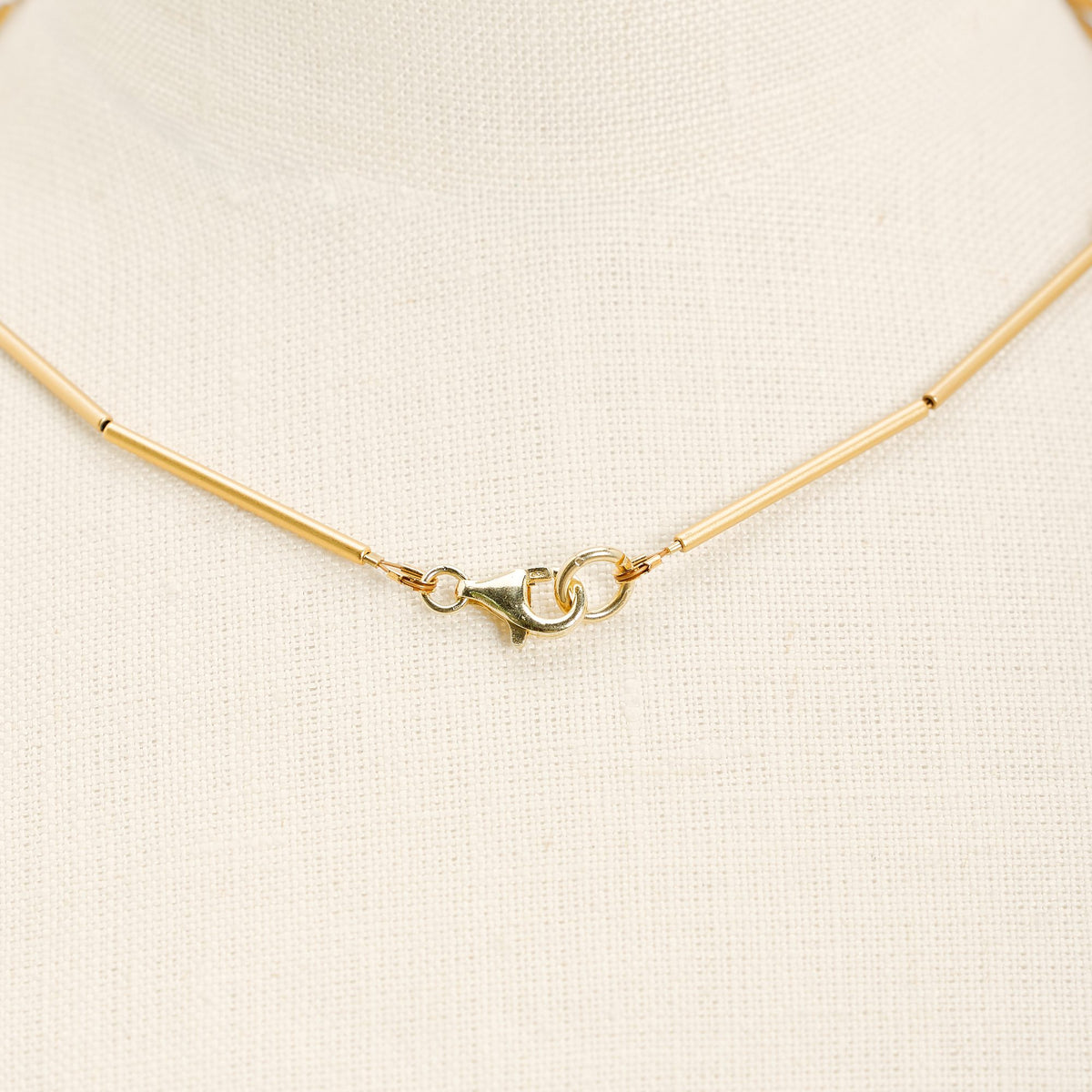 Collana Parentesi Oro in ottone dorato e argento 925, su fondo chiaro