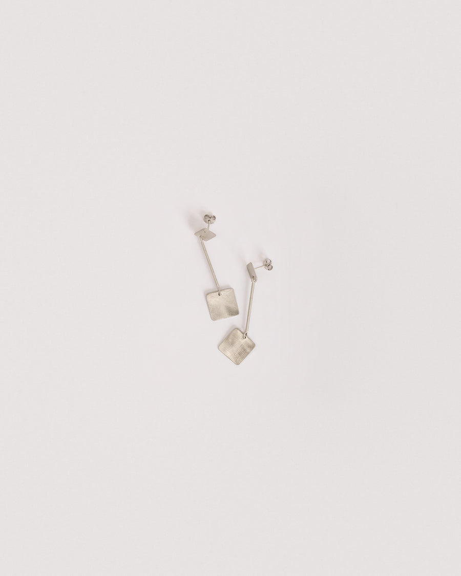 QB 2 Rhodium earrings in 925 sterling silver, on a light background