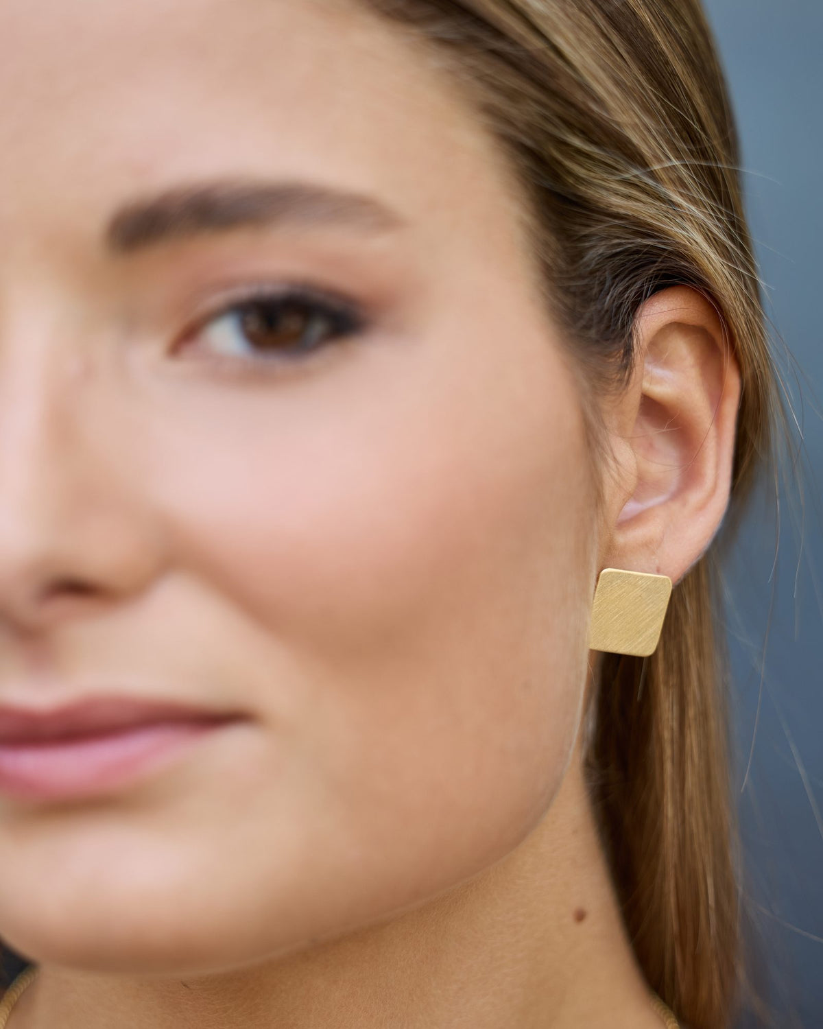 QB Gold earrings in 925 sterling silver, worn, close-up on the ear