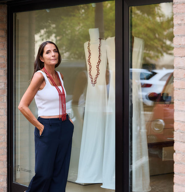 Donna davanti a una vetrina con una lunga collana rossa