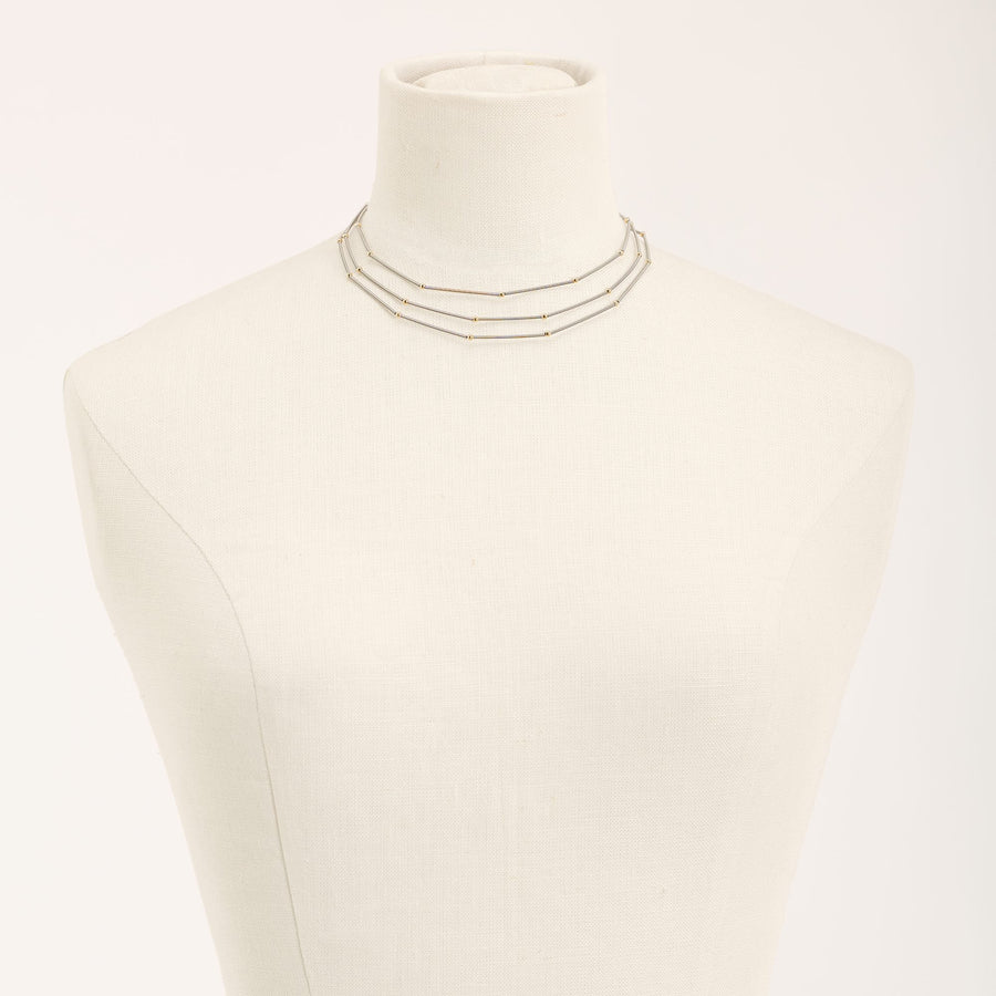 Collana Astro Tris Oro in acciaio e argento dorato, su fondo chiaro