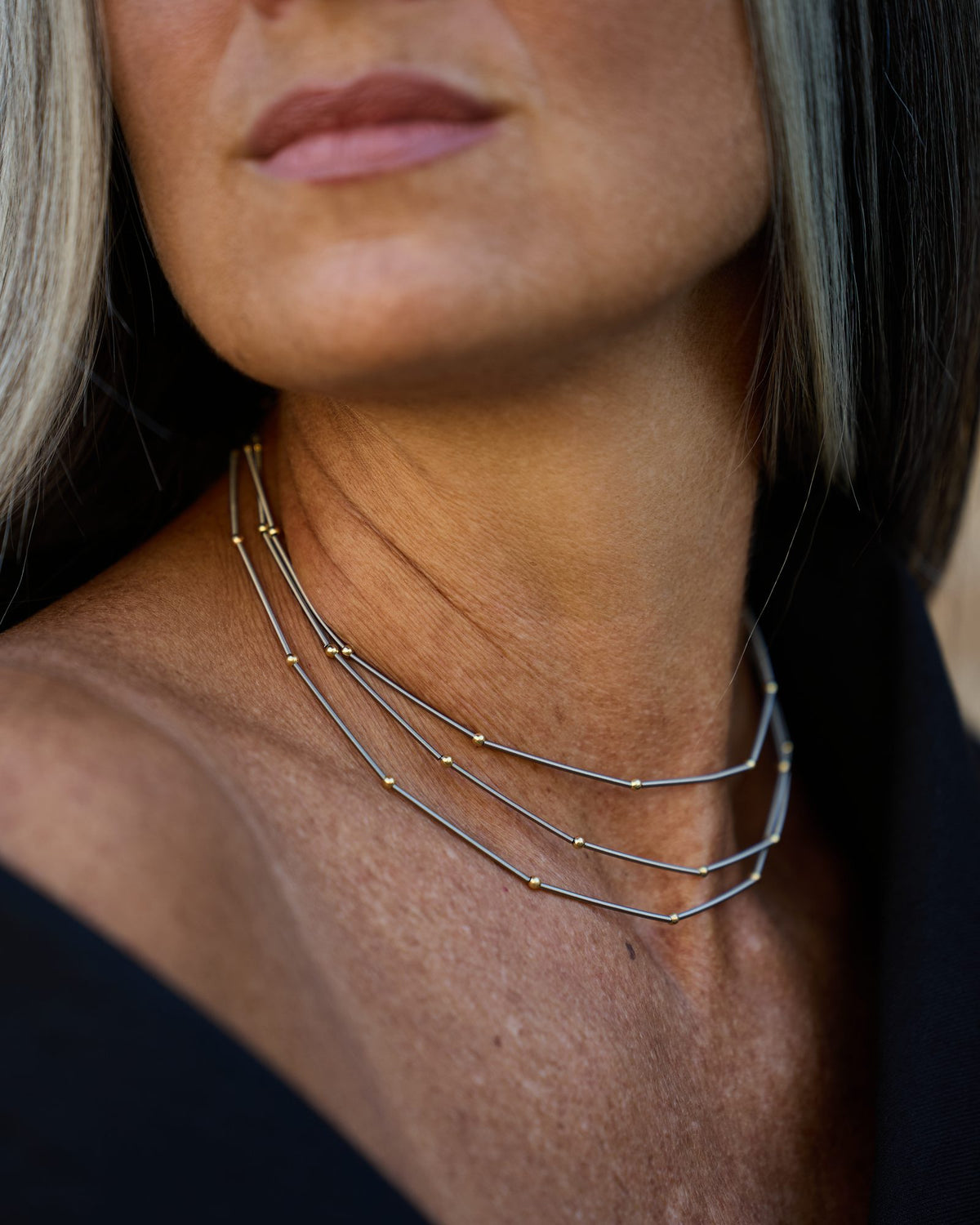 Collana Astro Tris Oro in acciaio e argento dorato, indossata, dettaglio ravvicinato