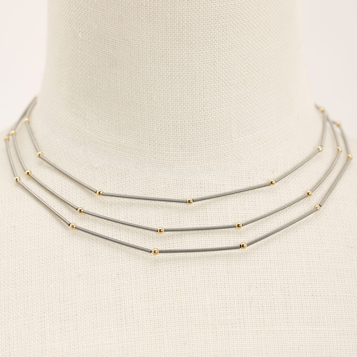 Collana Astro Tris Oro in acciaio e argento dorato, dettaglio ravvicinato su fondo chiaro