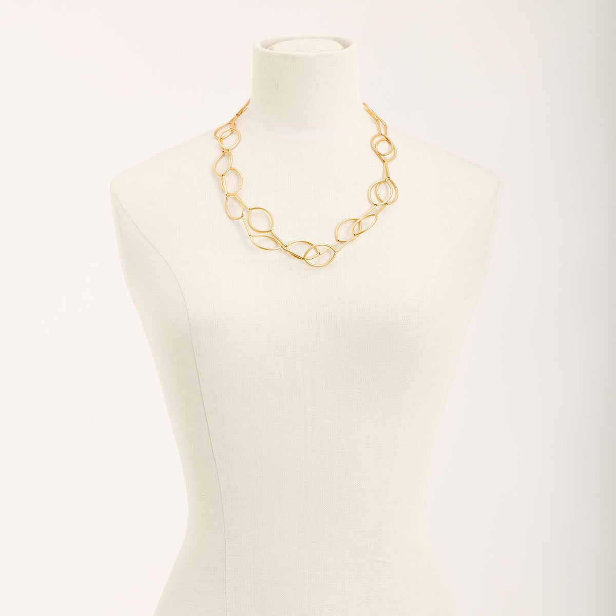 Collana Aurora Oro in tubini di ottone dorato satinato, su fondo chiaro