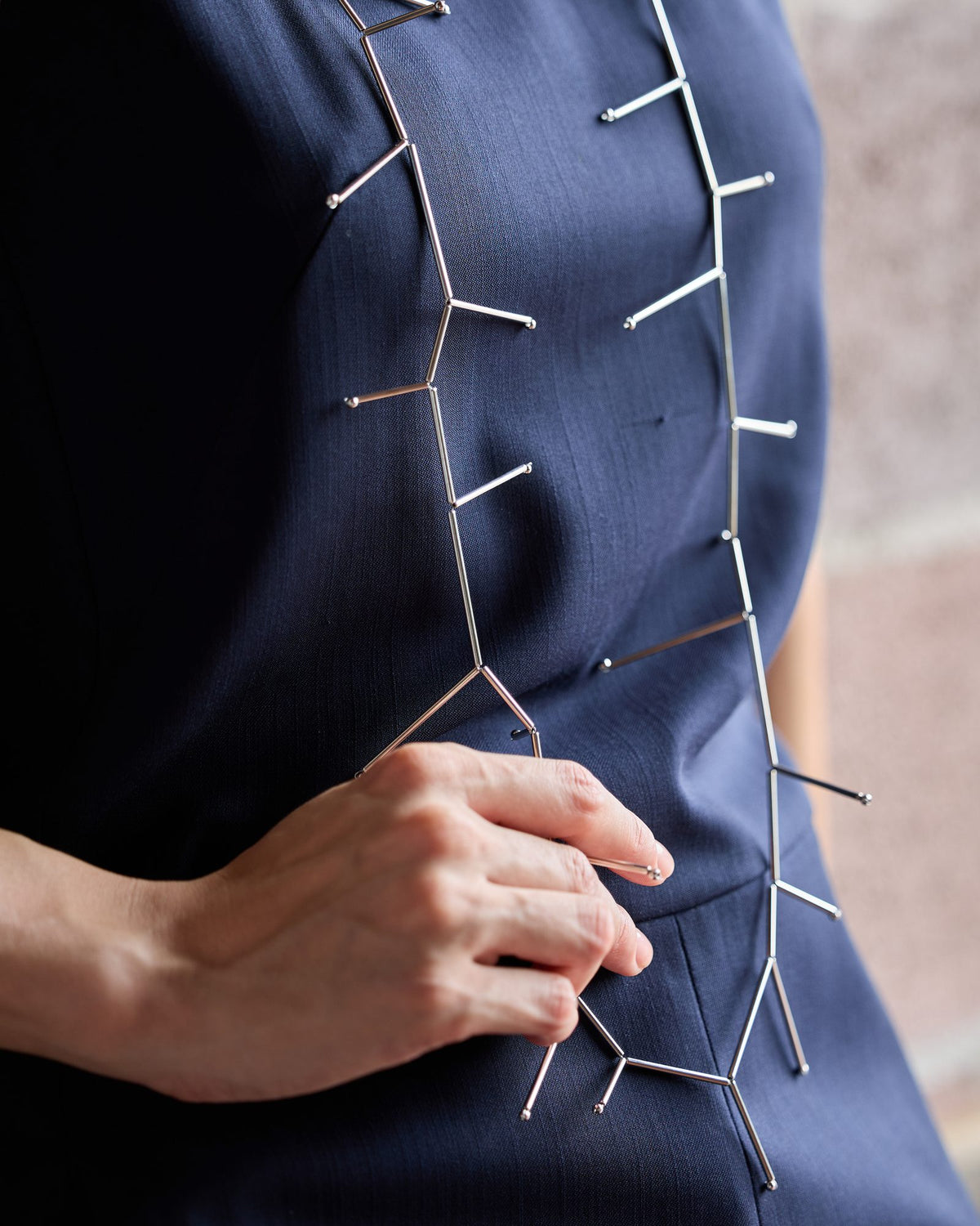 Collana Fenice Lunga Rodio in ottone rodiato e sfere in acciaio, indossata