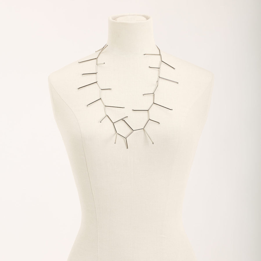 Collana Fenice Rodio in tubini in ottone rodiato e argento, su fondo chiaro