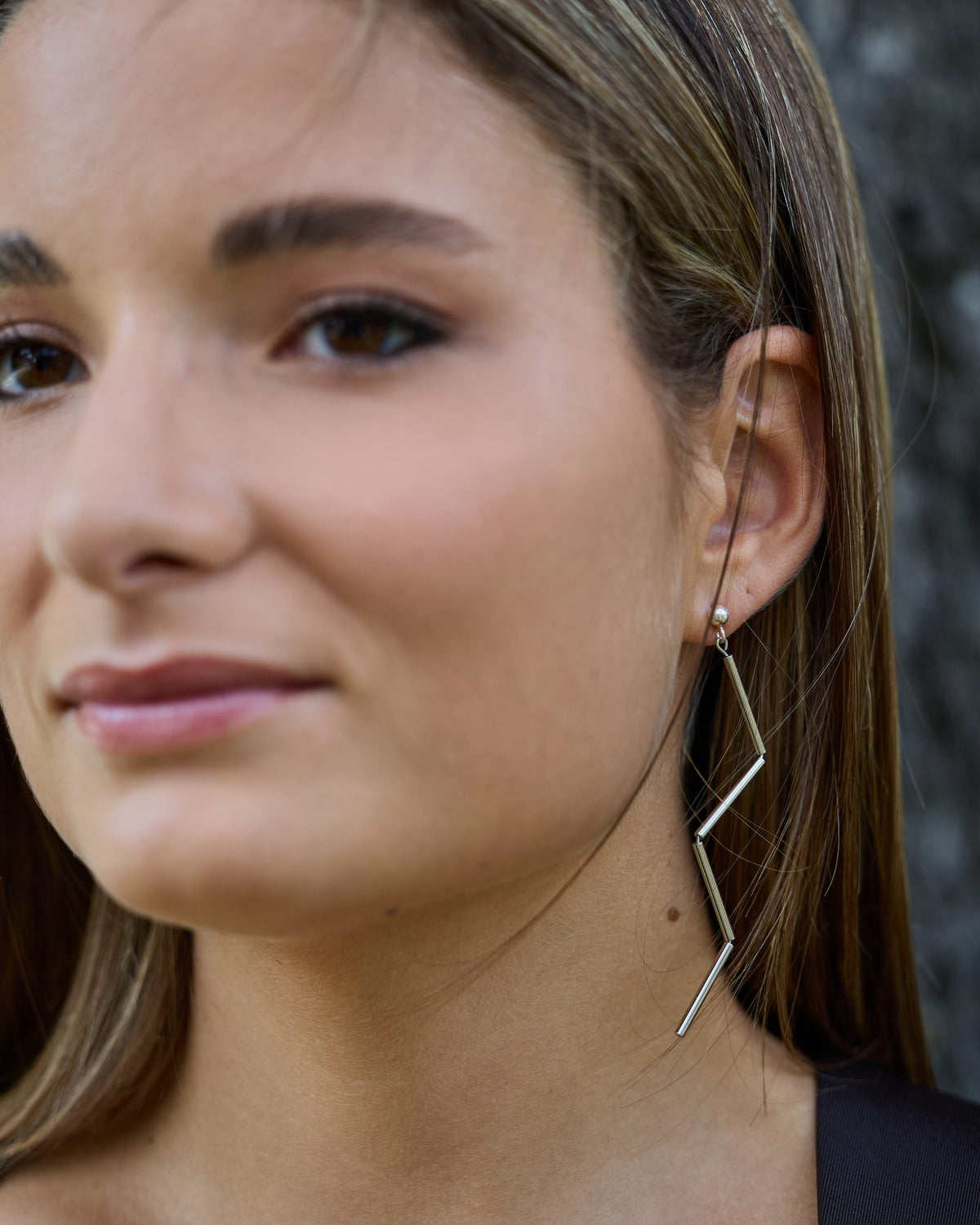 Orecchini Lampo Rodio in ottone rodiato e argento rodiato, indossati, dettaglio sull'orecchio