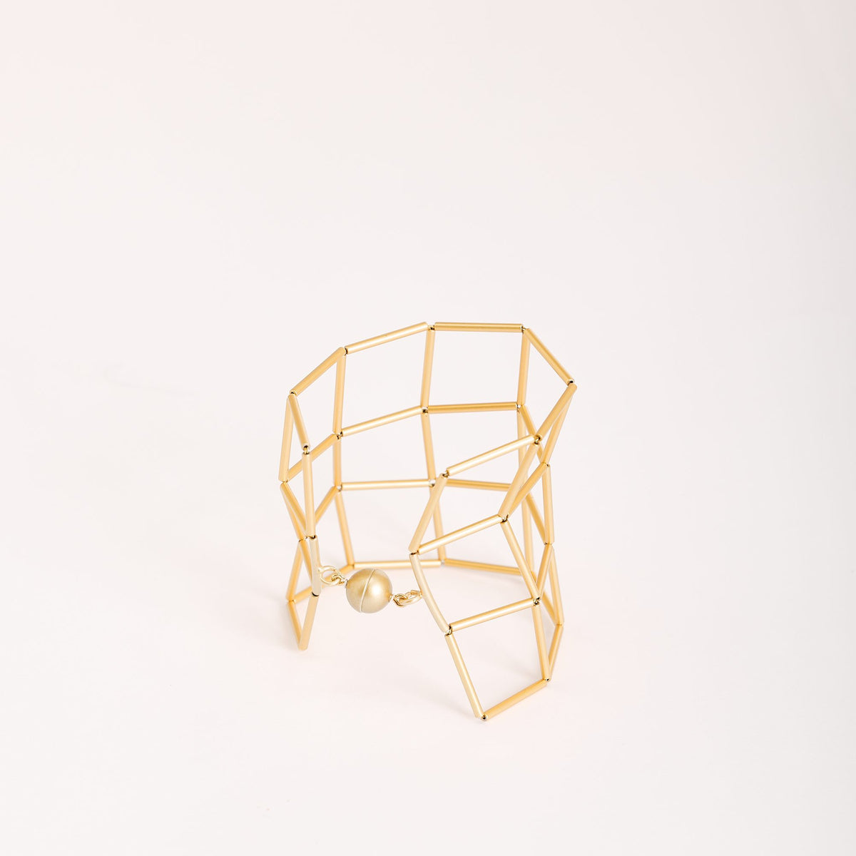 Bracciale Losanghe 3 Oro in ottone dorato e chiusura magnetica in resina, su fondo chiaro