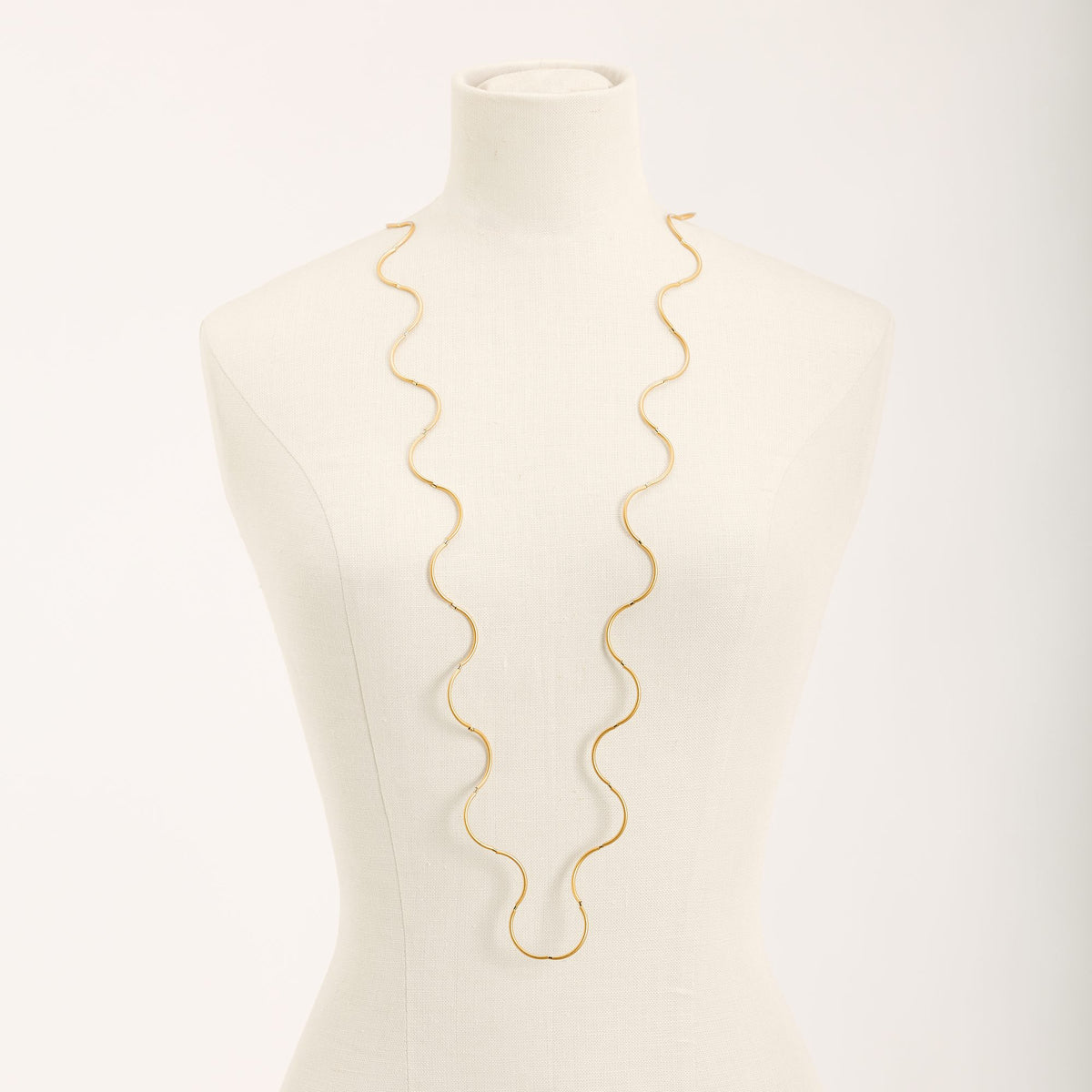 Collana Onda Oro in ottone dorato e tubini in argento dorato, su fondo chiaro