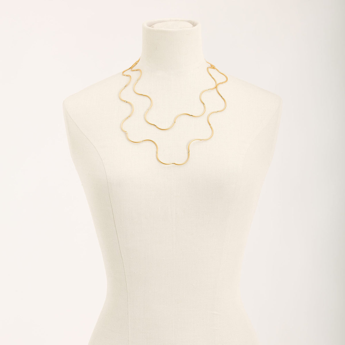 Collana Onda Oro in ottone dorato e tubini in argento dorato, su fondo chiaro