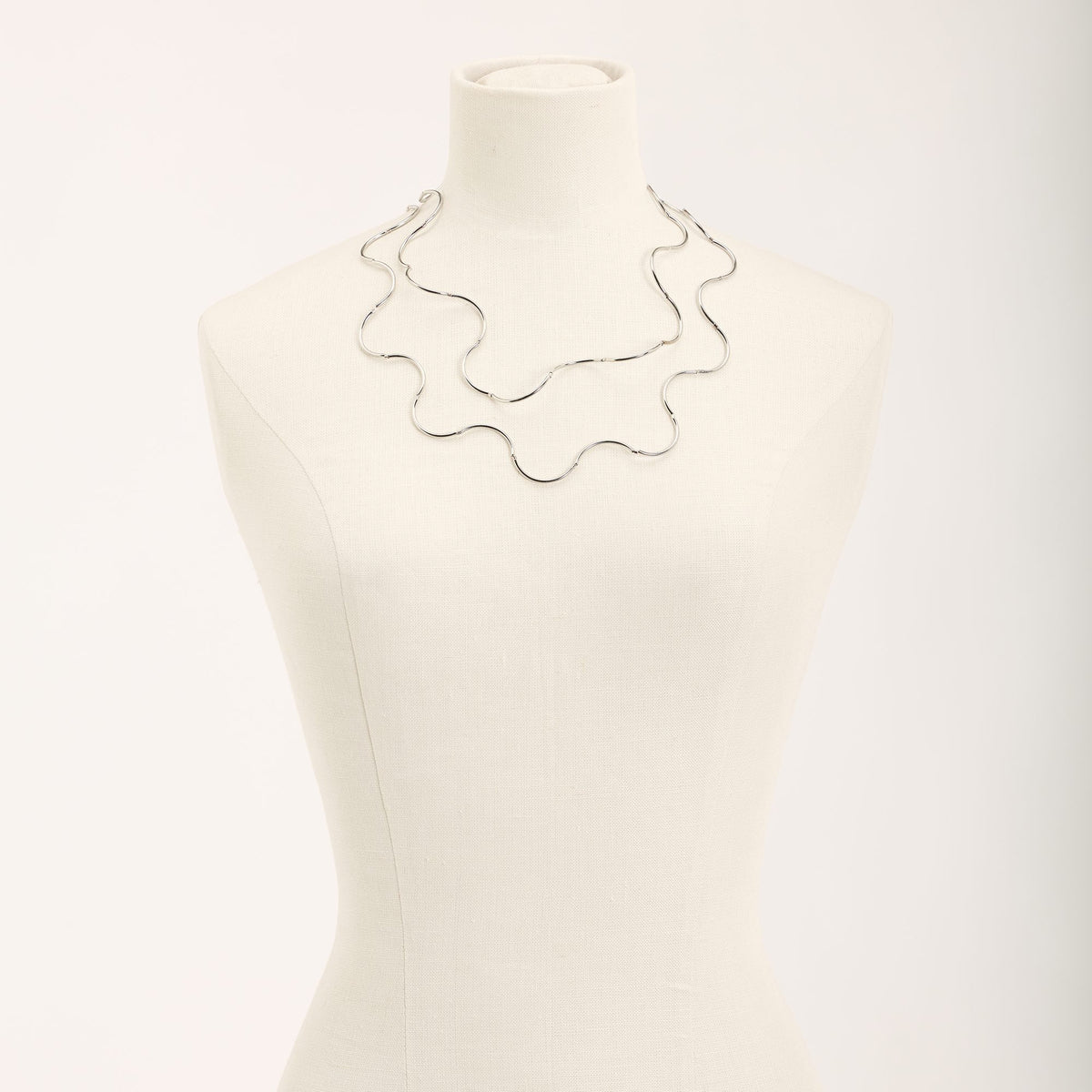 Collana Onda Rodio in ottone rodiato e tubini in argento rodiato, su fondo chiaro