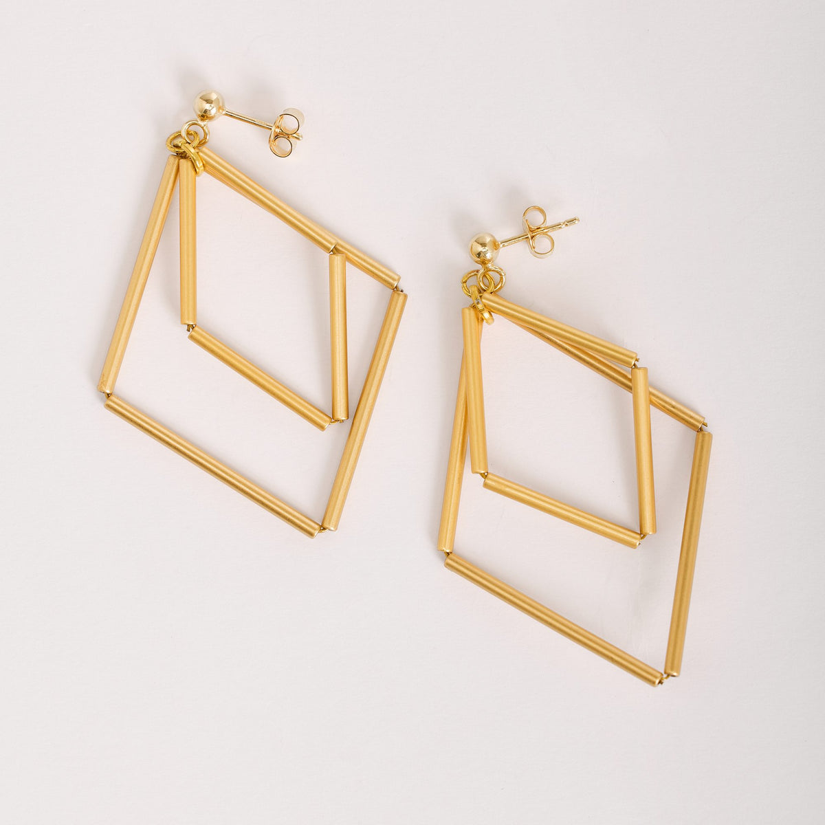 Paloma Gold earrings in gold-plated brass and silver, on a light background
