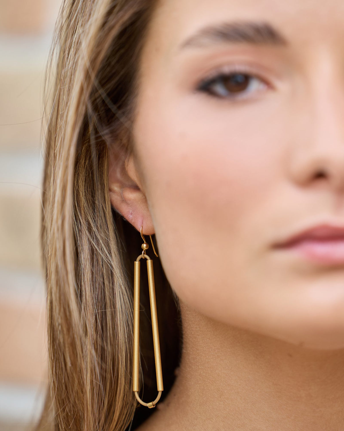 Orecchini Parentesi Oro in caucciù, ottone dorato e argento, indossati, dettaglio sull'orecchio