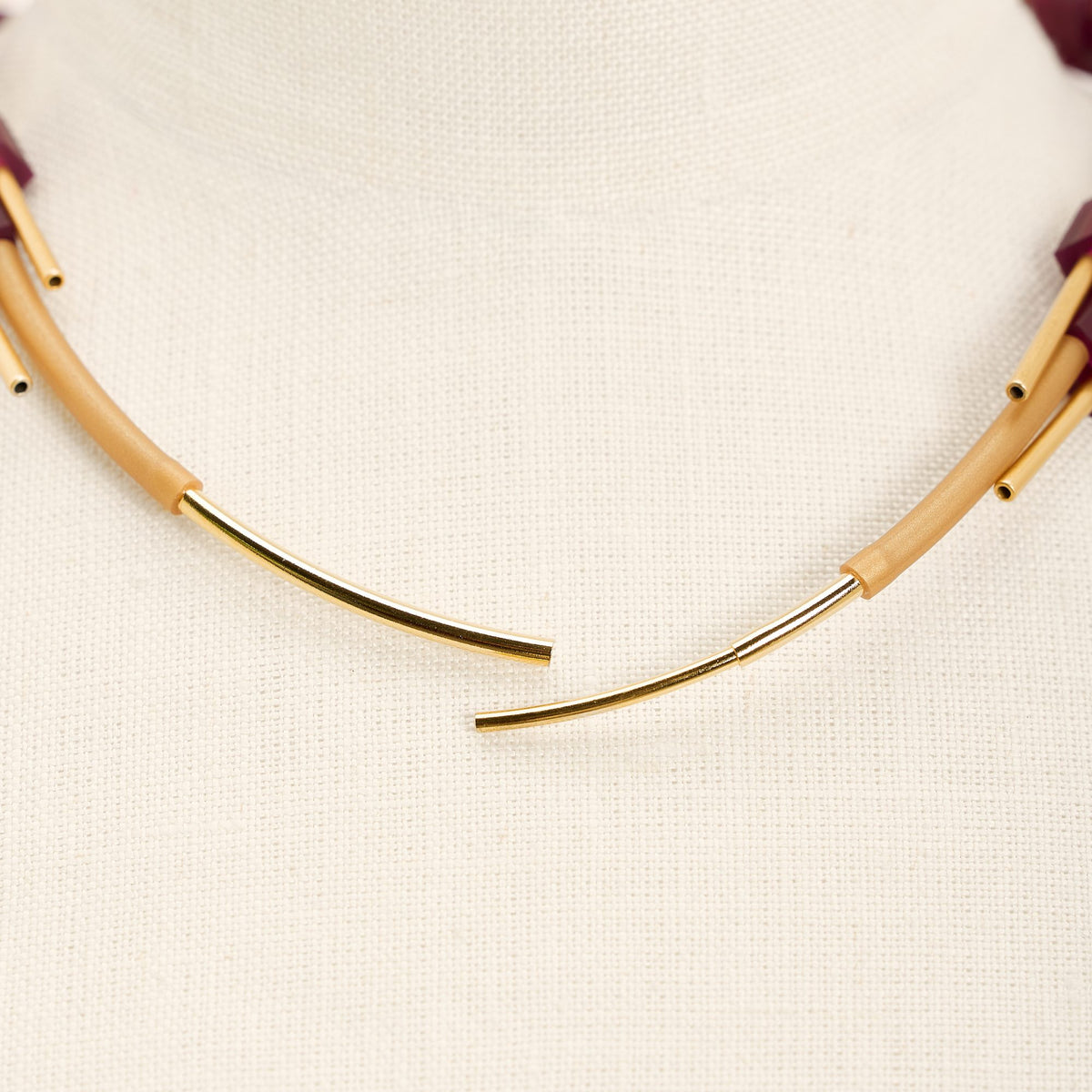 Collana Pasqua Oro in caucciù e ottone dorato, variante vinaccia, su fondo chiaro