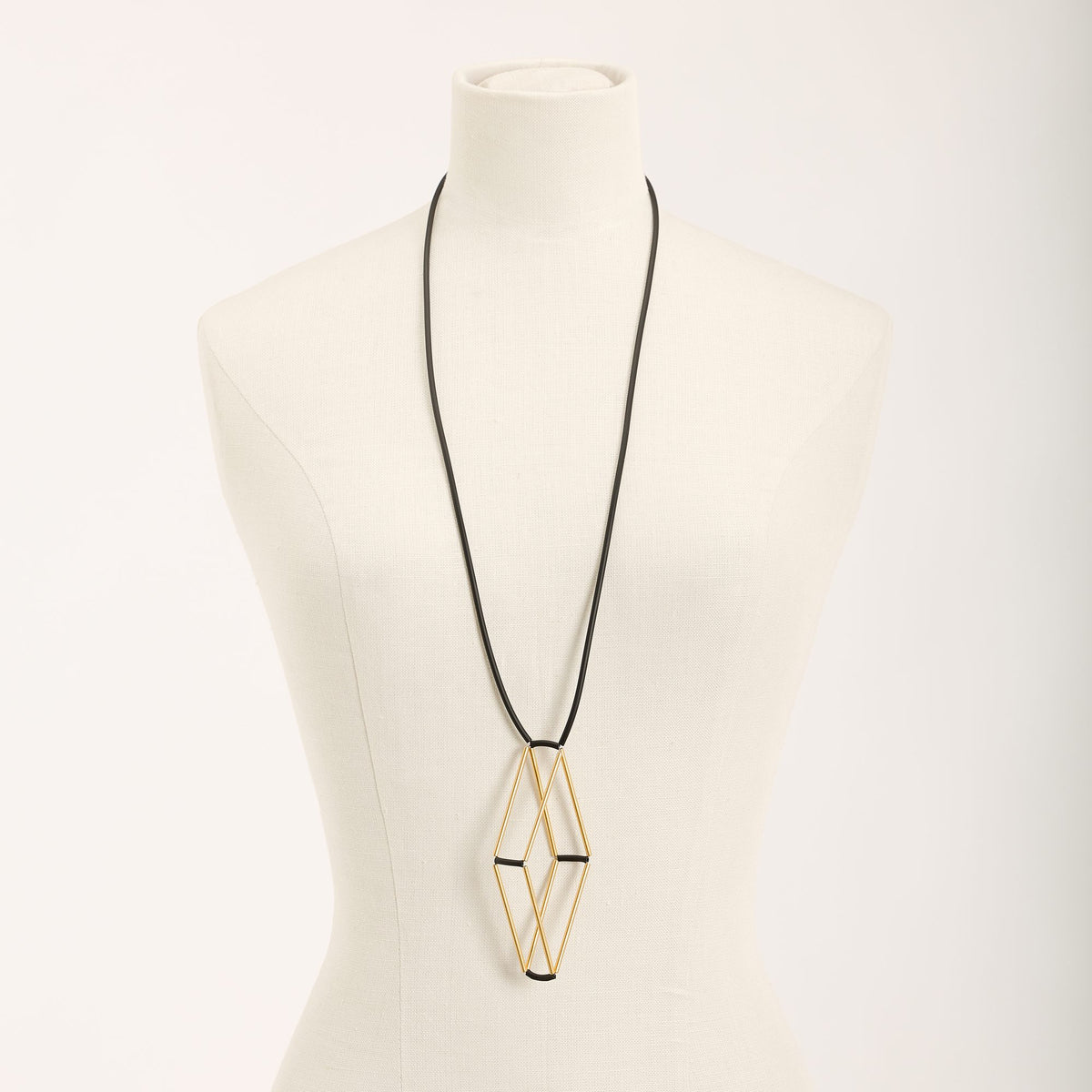Collana Teorema Oro in ottone dorato e caucciù, variante nero, su fondo chiaro